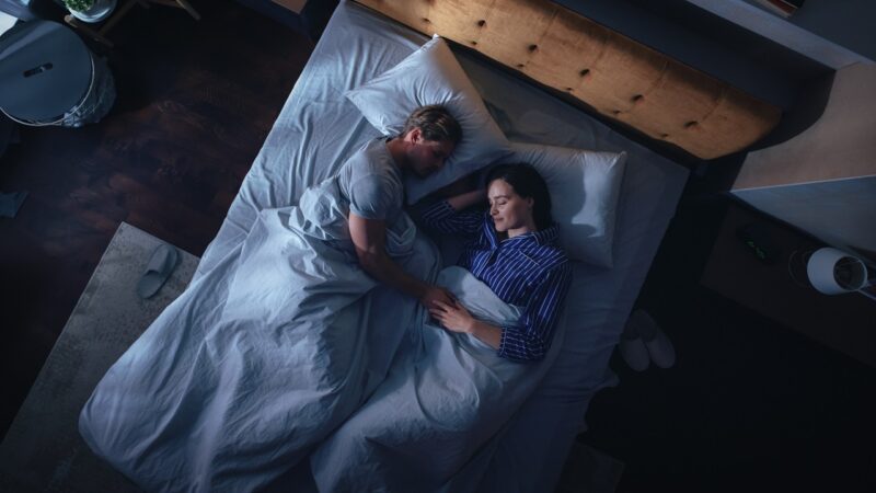 Couple sleeping together in an article by Stefanie Kuhn on what happens when couples stop sleeping together.
