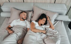 Couple lying in bed in an article by Stefanie Kuhn on mismatched libido.