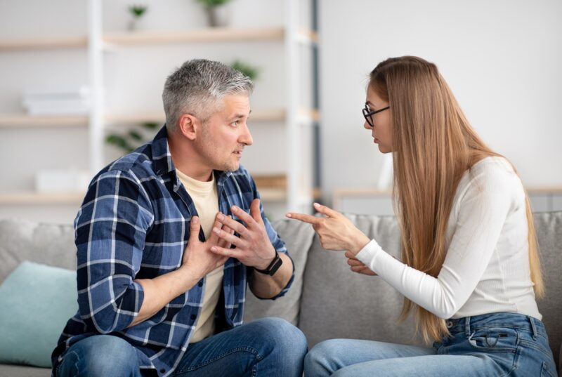 Irritated mature woman quarreling with her husband at home, being angry, experiencing family problems. Middle aged couple having conflict or disagreement. Marital crisis, breakup, divorce concept in an article explaining an emotional affair.