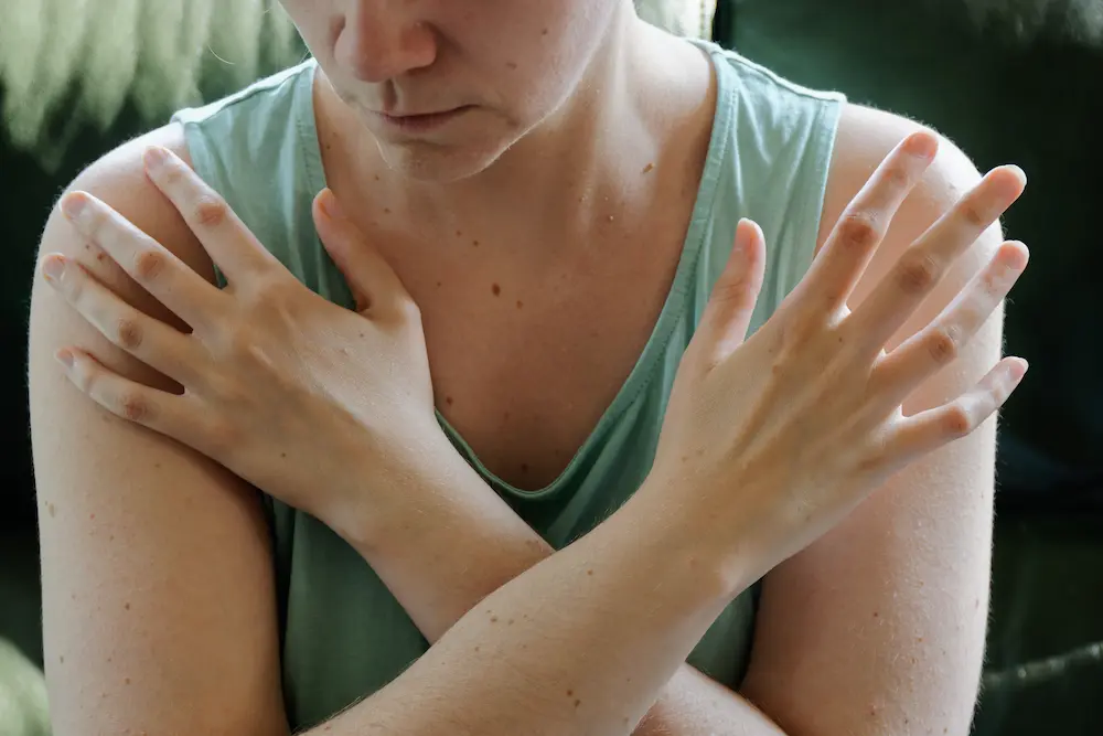 EMDR Therapy. Woman tapping her shoulders, crossing hands. Butterfly hug self-care technique.