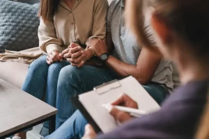 Couple holding hands during counseling at an intensive marriage retreat.