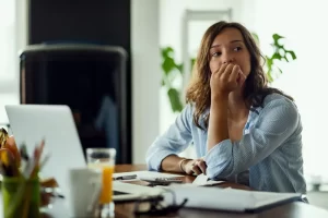 Worried woman sitting alone at a table reflecting on why she misses her affair partner